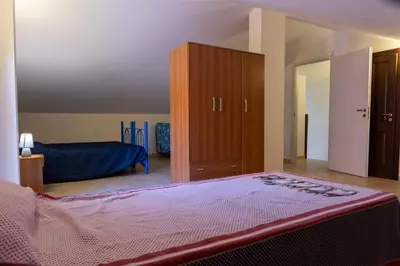 a bedroom with a bed and a wooden cabinet at Casa Vacanze Soleado house Trabia PA, Sicily in Mandra Capreria