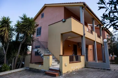 a house with stairs and a palm tree at Casa Vacanze Soleado house Trabia PA, Sicily in Mandra Capreria