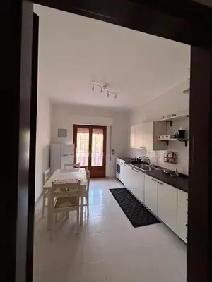 a kitchen with a table and a dining room at La casa dei Nonni in Santa Flavia