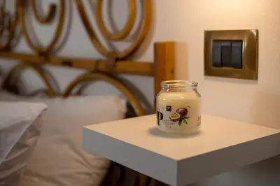 a jar of food sitting on a table next to a bed at Re Tancredi Apartment in Palermo