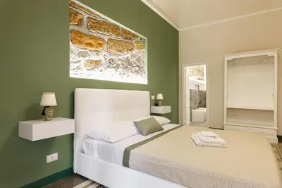 a bedroom with a bed with a painting on the wall at IG Holiday in Cinisi