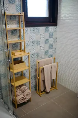a bathroom with a towel rack and towels at Villa Finch Mondello in Palermo