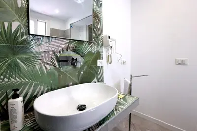 a bathroom with a white sink and a large plant at Ivi's House in Palermo