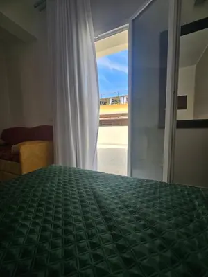 a bedroom with a green bed and a window at Alle Porte di San Vito in San Vito lo Capo