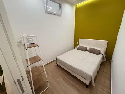 a small bedroom with a bed and a ladder at Casa Donna Ina in Palermo