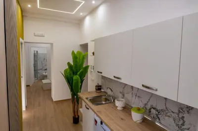 a kitchen with white cabinets and a sink at Casa Donna Ina in Palermo