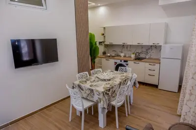 a dining room with a table and chairs and a kitchen at Casa Donna Ina in Palermo