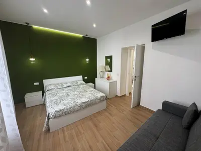 a bedroom with a bed and a green wall at Casa Donna Ina in Palermo