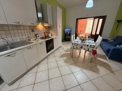 a kitchen and living room with a table and a couch at Nuovo Basile by Holiday World in Palermo
