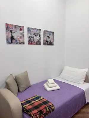 a bedroom with a bed and a small cabinet at Violet House in Palermo