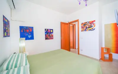 a bedroom with a green bed and paintings on the wall at Gorgeous Home In Trabia in Trabia