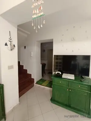 a living room with a green cabinet and a staircase at Villino Sirene Mondello in Palermo