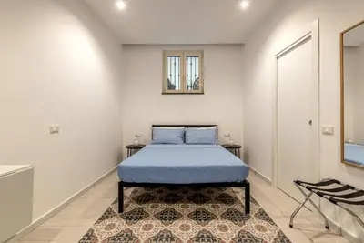 a bedroom with a bed with a blue bedspread at Ai Vicoli Ciambra's Alley by Wonderful Italy in Monreale
