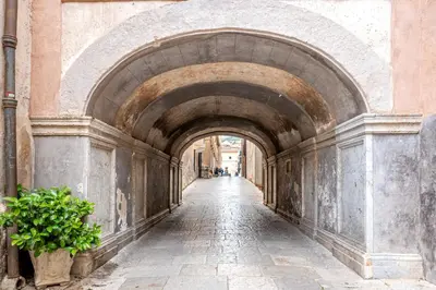 an alley way in a building with an archway at Ai Vicoli Ciambra's Alley by Wonderful Italy in Monreale