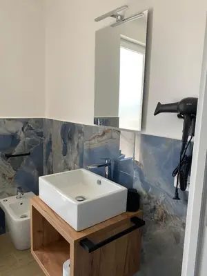 a bathroom with a white sink and a mirror at MARE Suite in Palermo