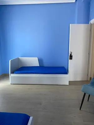 a bed in a room with a blue wall at MARE Suite in Palermo