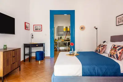 a bedroom with a bed and a desk and a television at Elegant Two-Room Apartment with Balcony & Suite in Palermo