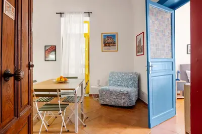 a room with a table and a chair and a blue door at Elegant Two-Room Apartment with Balcony & Suite in Palermo