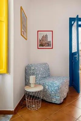 a living room with a chair and a table at Elegant Two-Room Apartment with Balcony & Suite in Palermo