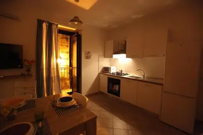 a small kitchen with a table and a refrigerator at Centro storico apartment & Loft - Amnesia Holiday Home in Palermo