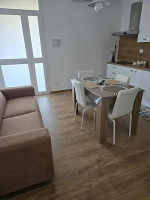 a living room with a table and a couch at Nonna Franca GuestHouse in Isola delle Femmine