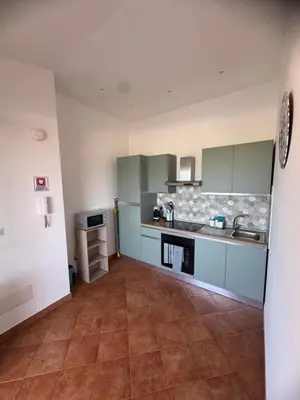 a kitchen with green cabinets and a tile floor at Dimora Solemar-Mareluna village in Campofelice di Roccella