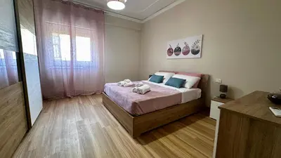 a bedroom with a bed with pink and blue pillows at Albachiara Apartment vicino al mare di Capaci in Capaci