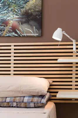 a bedroom with a wooden headboard with a lamp and a bed at Mondello suites FLH - Posidonia in Palermo