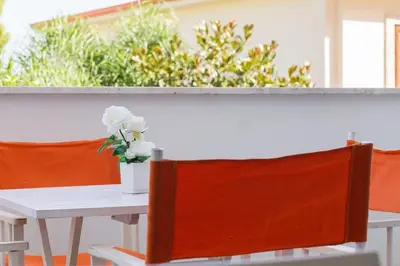 a table with a vase of white flowers on it at Mondello suites FLH - Posidonia in Palermo