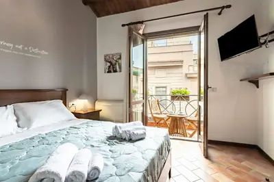 a bedroom with a bed and a balcony with a television at GuestHost - MiraVigghia Apartment in Palermo