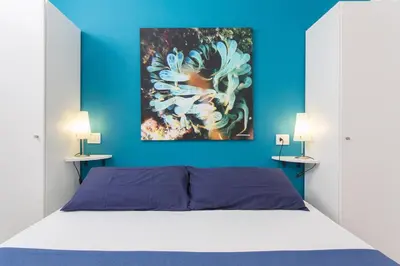 a bedroom with a bed with a painting on the wall at Mondello Suites FLH - Anemone in Palermo