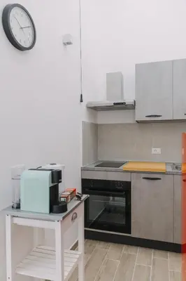 a kitchen with a stove and a clock on the wall at Serenello Home in Palermo