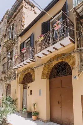 an old house with balconies and a garage at Serenello Home in Palermo