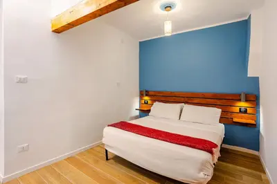 a bedroom with a bed with a red blanket on it at Casa Vacanza Dante 17 Carini in Carini