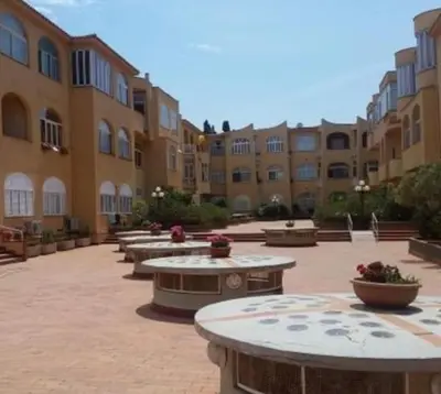 a courtyard with tables and benches in a building at Mondello Sea House in Palermo