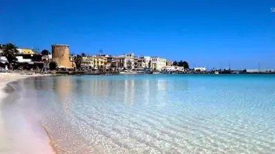 a large body of water with buildings in the background at Mondello Sea House in Palermo