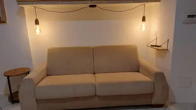 a couch in a room with lights on the wall at Casa dei normanni in Palermo