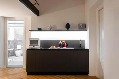 a kitchen with a black counter and a microwave at Dimora Ai Leoni, Suite & Apartments in Palermo