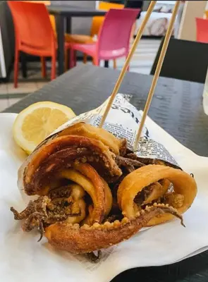 a plate of food with onion rings and a lemon at Il sole siciliano in Palermo