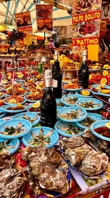 a table with plates of food and bottles of wine at Il sole siciliano in Palermo