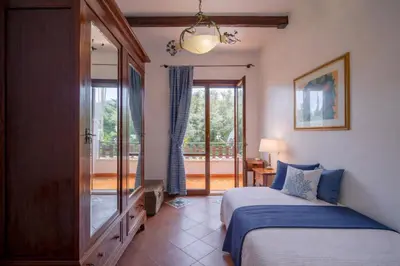 a bedroom with a white bed and a chair at Le Sicilien - Villa Harmony - Relax a Mondello in Palermo