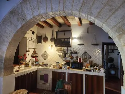 a large kitchen with an archway in a building at Villa Kinisia, antica dimora siciliana in Cinisi