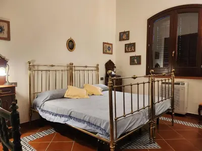 a living room with a red couch and a table at Villa Kinisia, antica dimora siciliana in Cinisi
