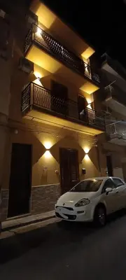 a white car parked in front of a building at night at Casa vacanze I mori in Bagheria