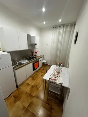 a kitchen with a table and a white refrigerator at Casa vacanze I mori in Bagheria