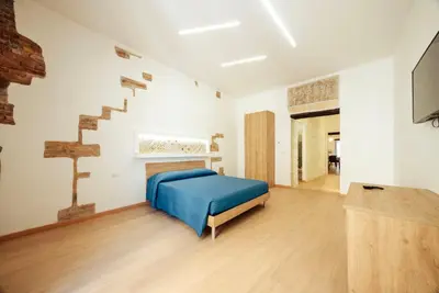 a bedroom with a blue bed and a staircase at Casa Ru Vecchio Re in Palermo