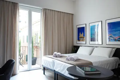a bed with towels on it with four pictures at Palermo Holiday House - Elegant Rooms near Politeama in Palermo