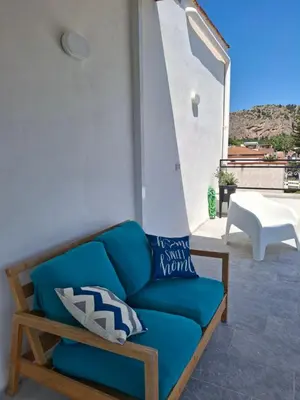 a blue couch with pillows on a patio at Mondello House29 in Palermo