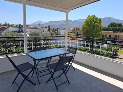 a table and chairs on a balcony with a view at Mondello House29 in Palermo