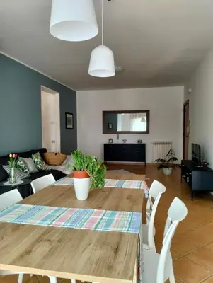 a dining room and living room with a table and chairs at Il mare negli occhi in Porticello